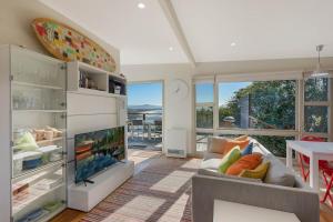 a living room with a couch and a tv at The Love Shack in Pambula