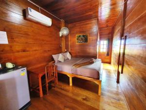 a room with a bed and a desk in a wooden room at Perfect Resort Sukhothai & motorbikes for rent & bicycles for rent in Sukhothai