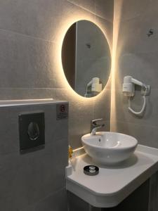 a bathroom with a white sink and a mirror at Dokos Studios in Parga