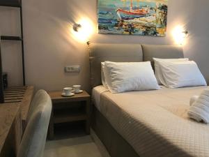 a bedroom with two beds and a painting on the wall at Dokos Studios in Parga