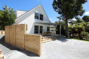 a house with a wooden fence in front of it at Gemini Lodge in Rotorua