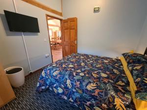 Schlafzimmer mit einem Bett und einem Flachbild-TV in der Unterkunft Inviting 2 bedroom barn conversion rural Norfolk in Loddon