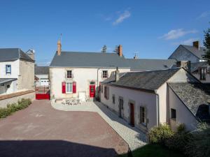 ein großes weißes Haus mit roten Türen und einem Innenhof in der Unterkunft Gîte Aschères-le-Marché, 4 pièces, 6 personnes - FR-1-590-17 