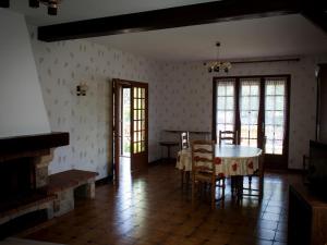 una sala da pranzo con tavolo, sedie e finestre di Gîte Artenay, 4 pièces, 5 personnes - FR-1-590-123 ad Artenay