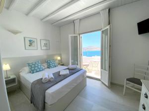 a bedroom with a bed with a view of the ocean at Anthos Apartments in Naousa