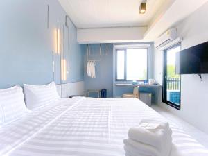 帕夭ABIZZ Hotel KwanPhayao的卧室里有一张白色的大床和一扇窗户