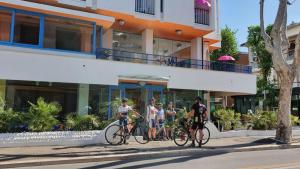 un grupo de personas en bicicleta delante de un edificio en Hotel Senior, en Cattolica