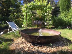 un baño de aves con una fuente en un patio en L 'Havéli, en Vaison-la-Romaine