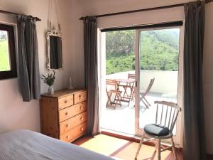 a bedroom with a bed and a sliding glass door at Casa Bordeira in Bordeira