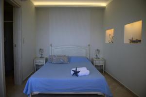una camera da letto con letto con lenzuola e asciugamani blu di Villa Nostalgia Lentas No3 a Lentas