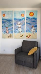 コウォブジェクにあるImpresja 42 Apartament z garażemの壁に四枚の絵画が飾られた部屋のソファ