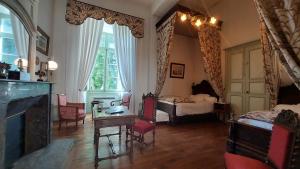 a living room with a bed and a table and chairs at Château de Ternay in Ternay