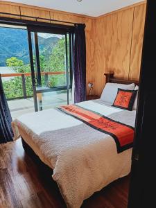 sypialnia z łóżkiem i dużym oknem w obiekcie Marlborough Sounds Accommodation 792 w mieście Havelock