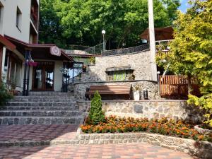 a stone building with a bench and flowers at Melania in Umanʼ