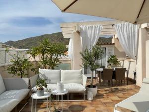 a balcony with white furniture and a table and chairs at Penthouse La Azohia Beach in La Azohía