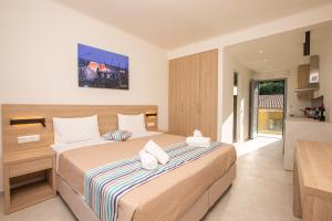 a bedroom with a large bed in a room at Passas Mare Apartments & Studios in Benitses +58 photos