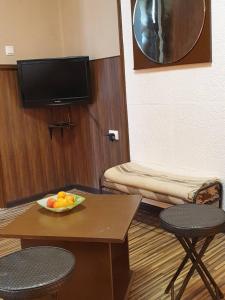 een kamer met een tafel met een fruitschaal erop bij KM!Sofia - Стаи за гости in Sofia