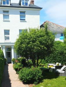 una casa blanca con una pasarela frente a un patio en The Swallows B and B en Exmouth