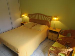 a bedroom with a bed with two lamps and a chair at Locatlantique in Aytré