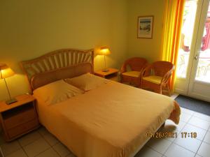 a bedroom with a large bed and two chairs at Locatlantique in Aytré