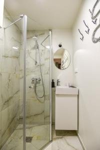 a bathroom with a shower and a sink at Neringos apartamentai in Palanga