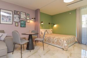 a bedroom with a bed and a table and chairs at Neringos apartamentai in Palanga +10 photos