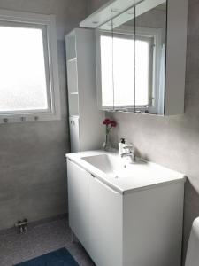 a bathroom with a white sink and a mirror at The White and Black House in Kalix