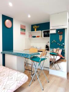 uma cozinha com mesa e cadeiras num quarto em Joli studio rénové en bord de mer em Bormes-les-Mimosas
