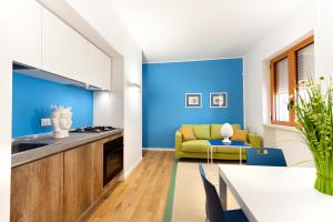a kitchen with blue walls and a table and a couch at Appartamenti fronte mare Otranto in Otranto