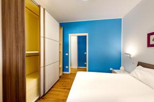 Appartamenti fronte mare Otranto في أوترانتو: غرفة نوم بسرير وجدار ازرق