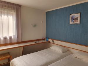 a bedroom with two beds and a blue wall at HOTEL Chateau-Thierry Centre in Château-Thierry