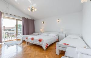 a white bedroom with two beds and a balcony at Apartments and Rooms Lago Rupa in Rupa +73 photos