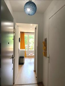 a hallway with a door and a light fixture at Joli studio rénové en bord de mer in Bormes-les-Mimosas