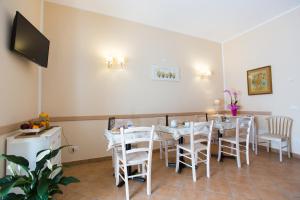 a dining room with tables and chairs and a flat screen tv at Casa Lollobrigida in Ciampino