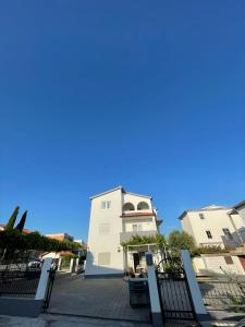 ein weißes Gebäude mit blauem Himmel im Hintergrund in der Unterkunft Apartments Antea in Rogoznica
