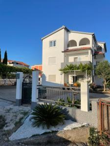 ein weißes Haus mit einem Tor und einem Zaun in der Unterkunft Apartments Antea in Rogoznica