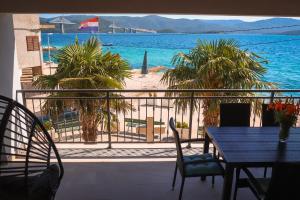 balkon ze stołem i krzesłami oraz widokiem na ocean w obiekcie Apartment Frana w mieście Komarna