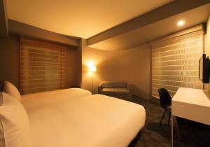 a hotel room with a bed and two lamps at Agora Place Tokyo Asakusa in Tokyo