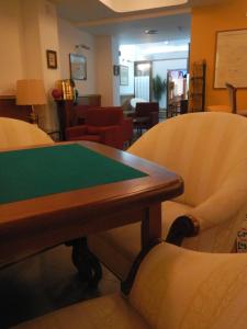 a conference room with a green table and chairs at Hostal Vila del Mar in Lloret de Mar