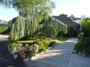 einen Garten mit rosa und lila Blumen und einem Haus in der Unterkunft Hotel de la Bonnheure in Bracieux
