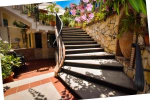 una scala che porta a un edificio fiorito di Hotel Condor a Taormina