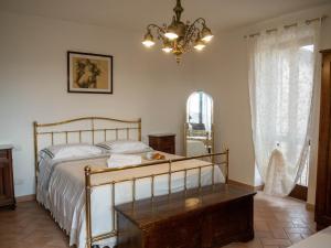 una camera con letto e lampadario a braccio di Domus Flora Guest House a Spello