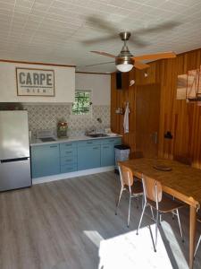 een keuken met een houten tafel en een koelkast bij RIBES - Chalet Gîte au coeur de la nature in Sournia