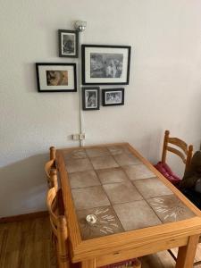 une table en bois dans une chambre avec des photos sur le mur dans l'établissement Le Prarion 2, aux Houches