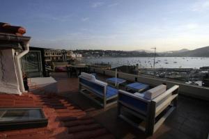a balcony with two benches and a view of the water at Pensión Iturriza in Donostia-San Sebastián