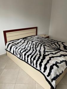 uma cama com estampa de zebra preto e branco num quarto em Super Apartment 100m2 2 sovrum em Shëngjin
