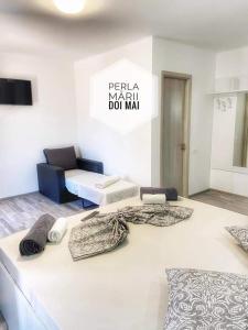 una camera con due letti e cuscini sul pavimento di Casa Perla Mării a 2 Mai Altre 6 foto