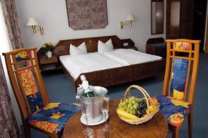a bedroom with a bed and a table with a bowl of fruit at Hotel Alter Speicher in Lübeck