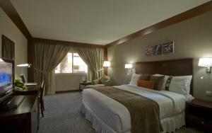 a hotel room with a large bed and a television at Holiday Inn Al Khobar - Corniche by IHG in Al Khobar