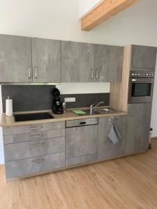 een keuken met roestvrijstalen kasten en een wastafel bij Silvias Ferienwohnung in Überlingen +35 foto's
